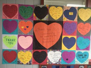 Image of student artwork with signatures.  Large orange heart "JCS Community thank you for supporting the Panther Pentathlon."