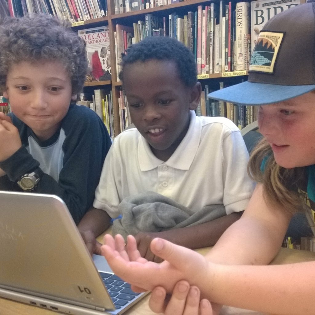 Three Boys Using A Chromebook For Hour Of Code