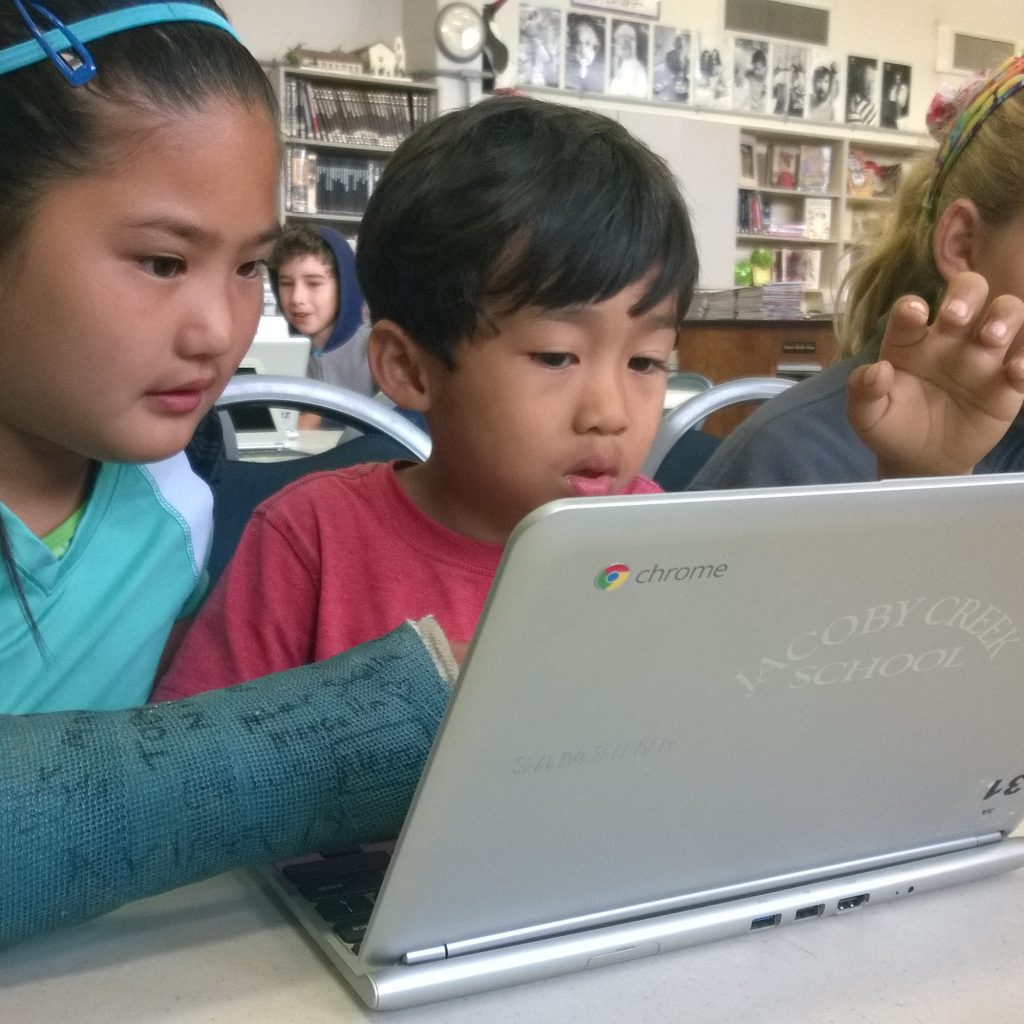 Two Girls And A Boy Are Using Chromebooks For Hour Of Code Project