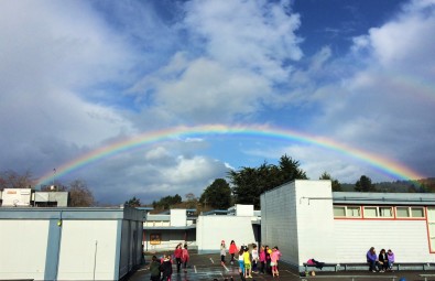 Spring Rainbow Over Jacoby Creek School With Students On Playground